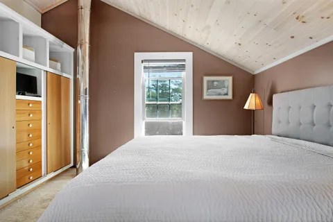 a bedroom with a large bed and a window