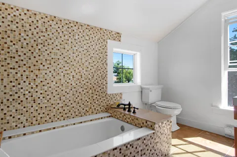 a bathroom with a bathtub and a window