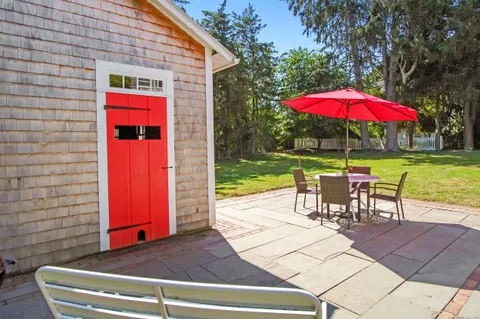 an outdoor sitting area with red umbrella