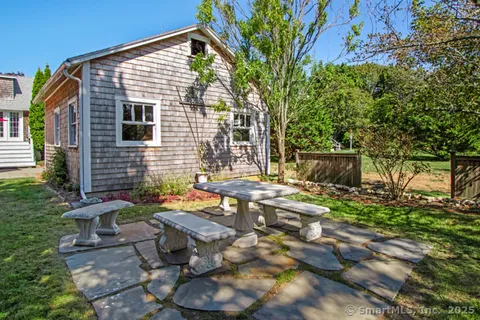 a backyard of a house with table and chairs