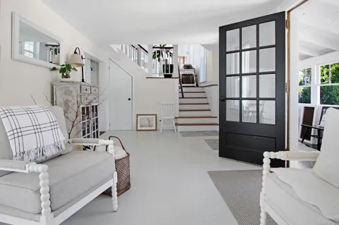 a living room with furniture windows and white walls