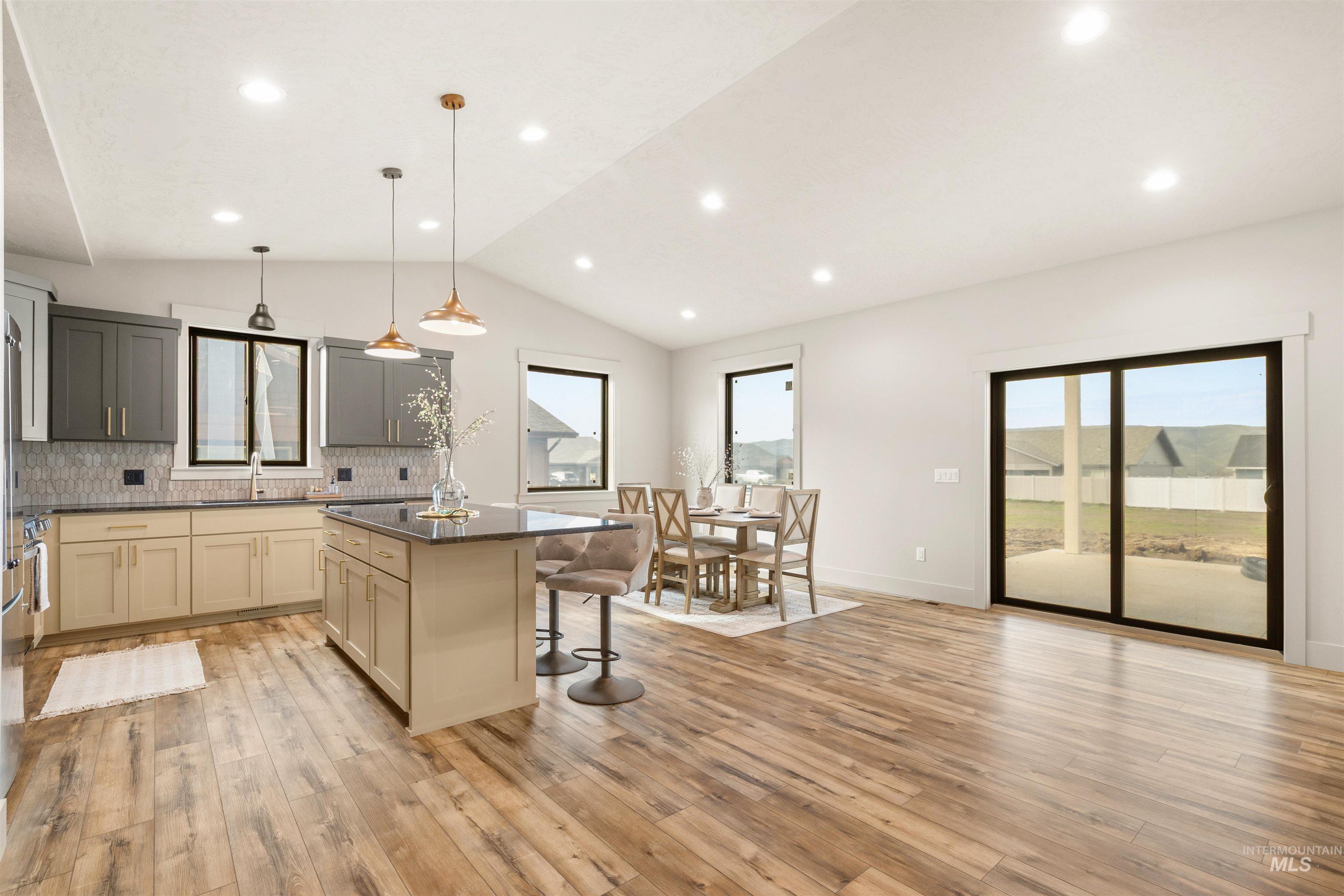 335 Warner Avenue Lewiston, ID 83501 - Photo 10 of 43 Kitchen with a kitchen breakfast bar, a center island, tasteful backsplash, cream cabinetry, and light wood-style floors