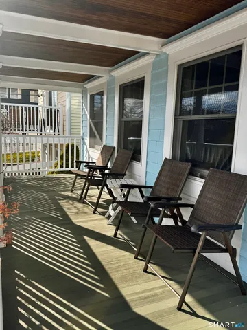 a view of a patio with table and chairs with wooden floor and fence