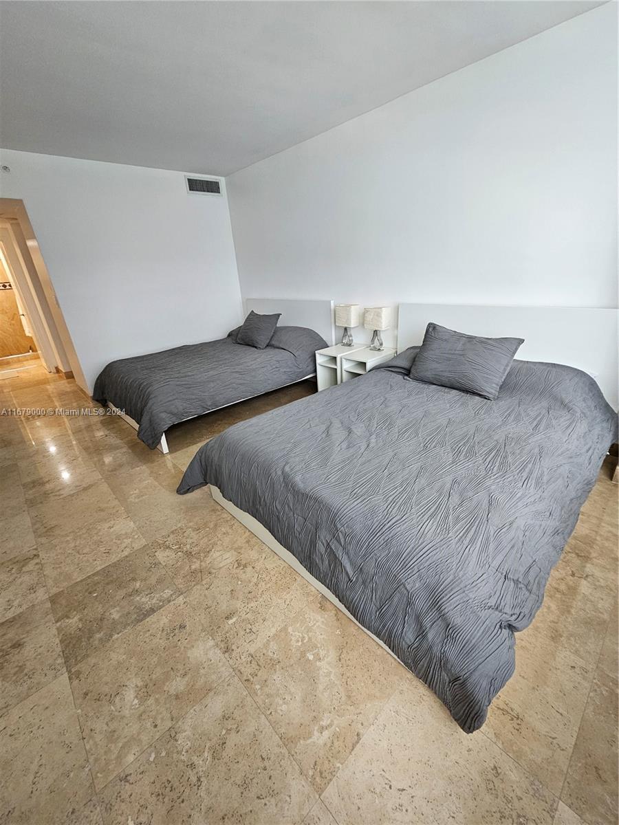 5601 Collins Avenue, Unit 1605 Miami Beach, FL 33140 - Photo 13 of 19 a bedroom with two beds and painted walls