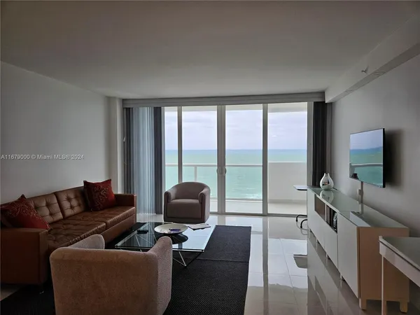 a living room with furniture and a floor to ceiling window