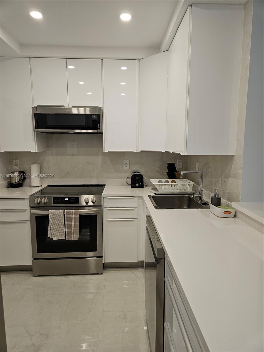 5601 Collins Avenue, Unit 1605 Miami Beach, FL 33140 - Photo 5 of 19 a kitchen with a stove and a sink