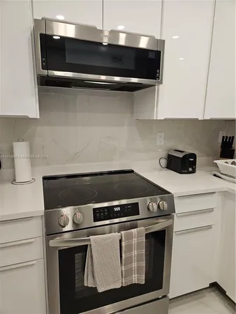 a stove top oven sitting inside of a kitchen