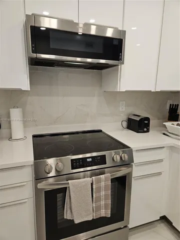 a stove top oven sitting inside of a kitchen