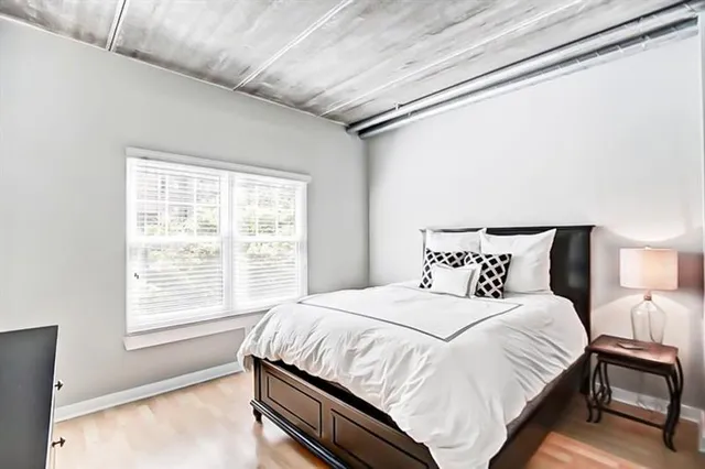 a bedroom with a bed and a large window with outer view