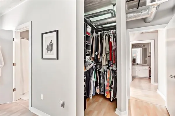 a view of walk in closet with clothes and shoes
