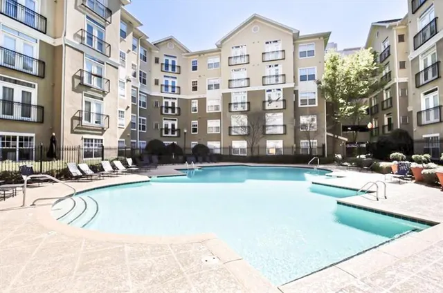 a swimming pool with buildings in the background
