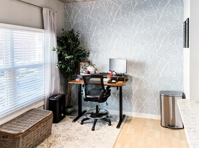 a view of a workspace with furniture and a window
