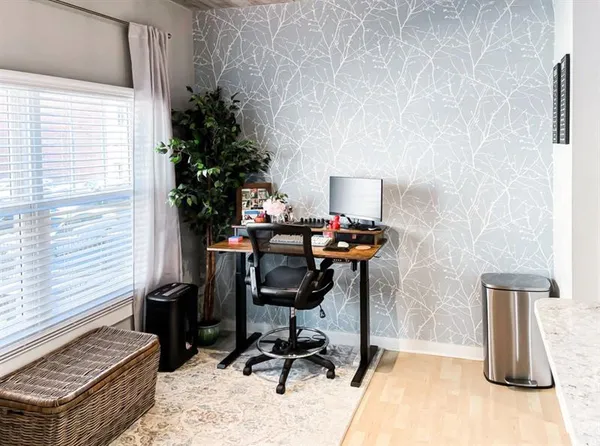 a view of a workspace with furniture and a window