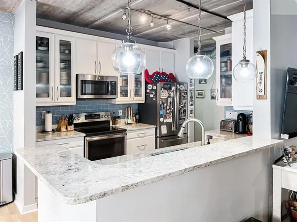 a kitchen with stainless steel appliances granite countertop a sink a stove and a microwave