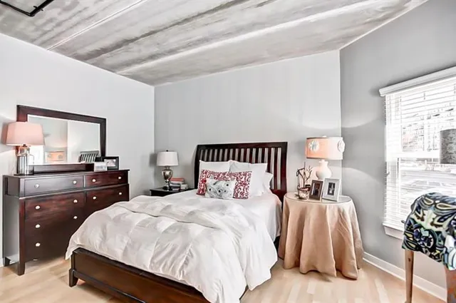 a bedroom with a bed and a mirror on dresser