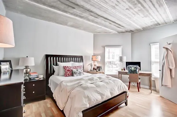 a bedroom with a bed and wooden floor