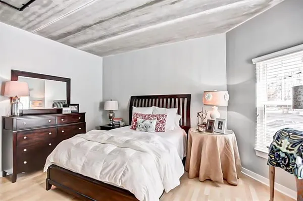 a bedroom with a bed and a mirror on dresser