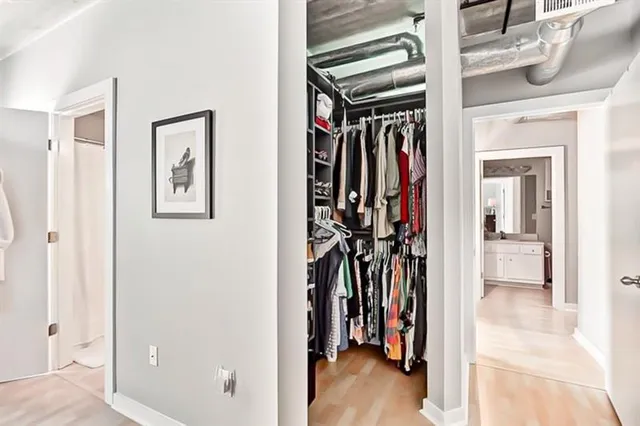 a view of walk in closet with clothes and shoes