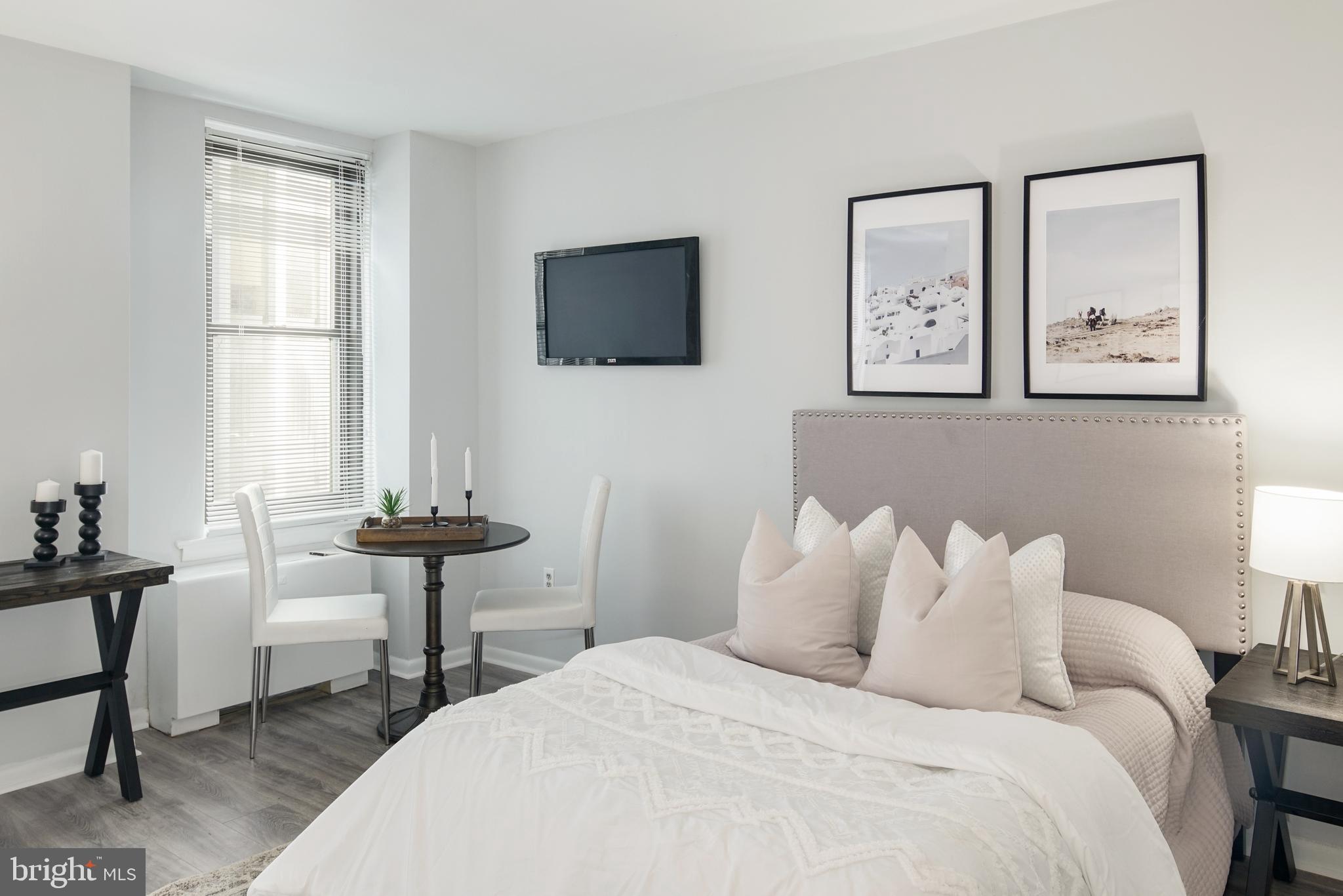 135 South 19th Street, Unit 913 Philadelphia, PA 19103 - Photo 2 of 15 a bedroom with a bed and a table