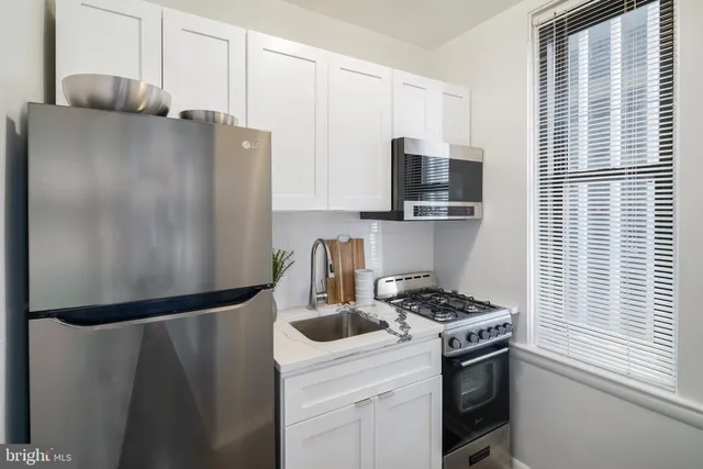 a kitchen with a refrigerator stove and sink