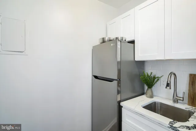 a kitchen with refrigerator and cabinets