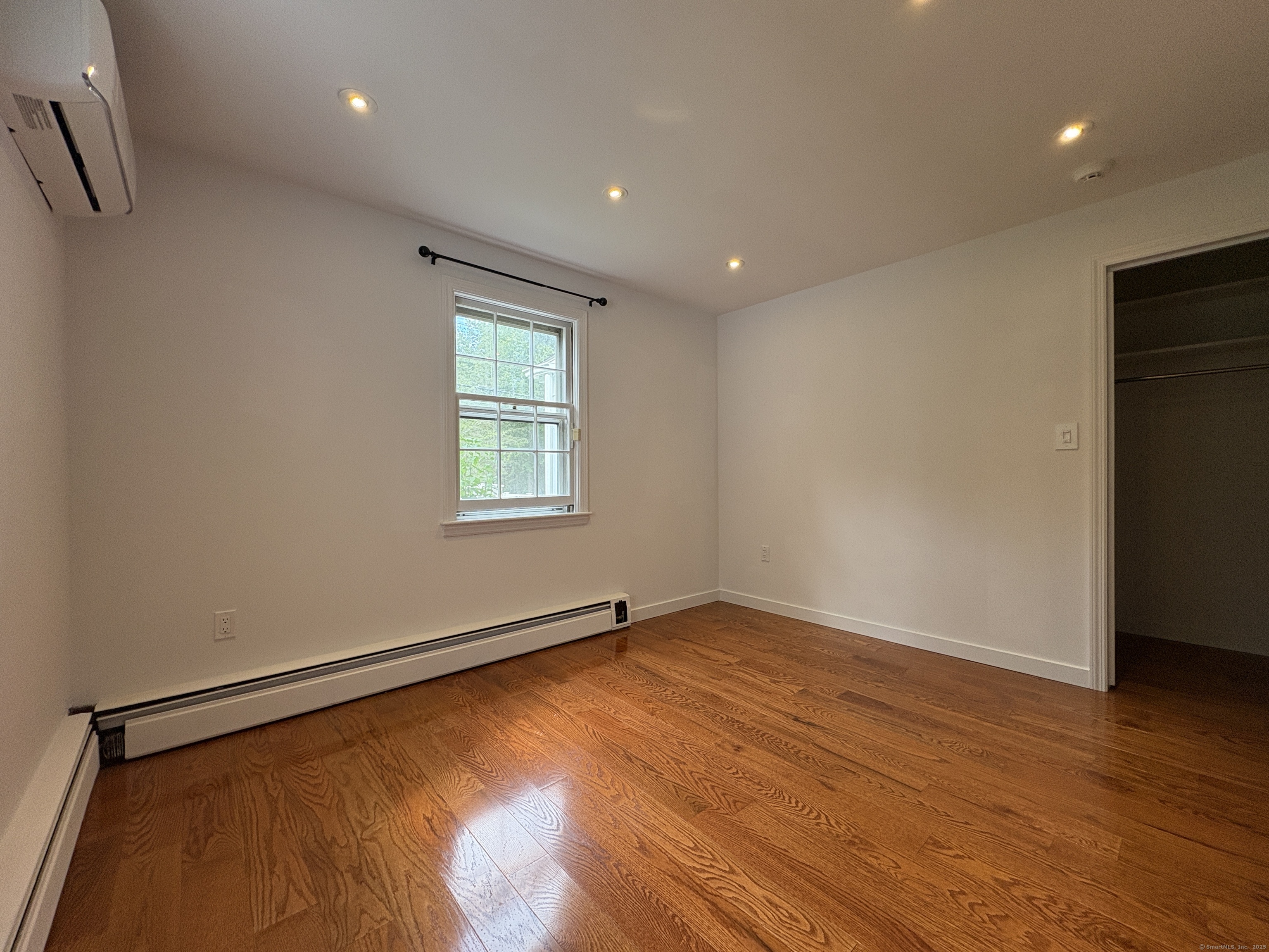158 Jelliff Mill Road New Canaan, CT 06840 - Photo 19 of 40 a view of an empty room with wooden floor and a window