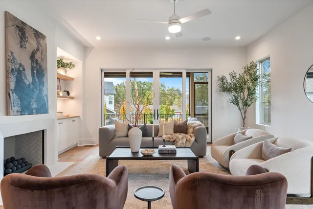 a living room with fireplace furniture and a large window
