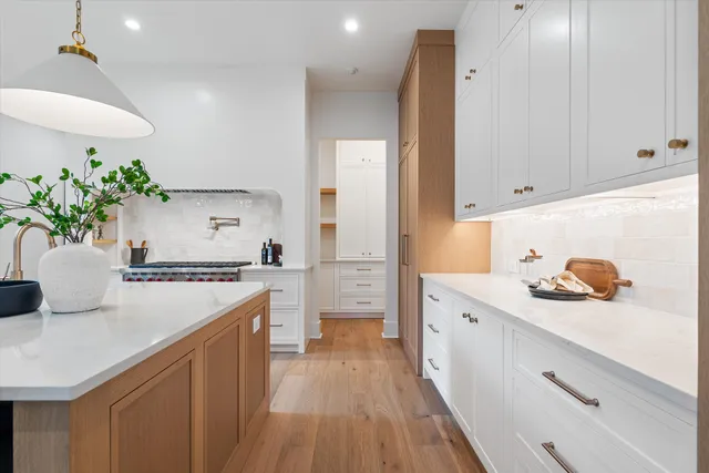 a kitchen with a white stove top oven and white cabinets