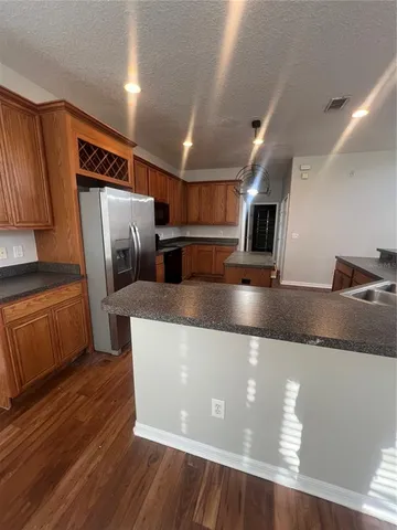a kitchen with stainless steel appliances granite countertop a refrigerator a sink and a stove