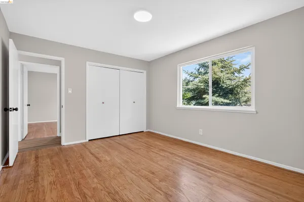 a view of an empty room with wooden floor