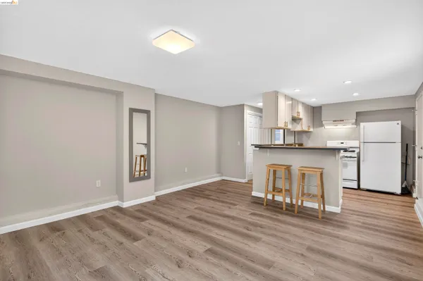 a kitchen with a sink and a stove with wooden floor