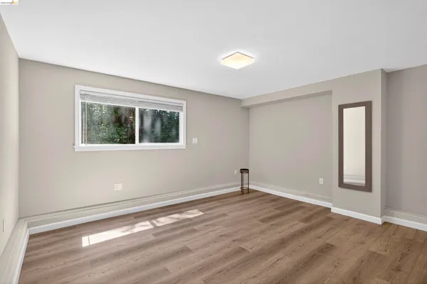a view of an empty room with wooden floor