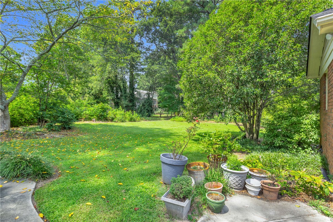 203 Fox Creek Road Anderson, SC 29621 - Photo 29 of 36 This spacious backyard offers a verdant lawn surrounded by mature trees, creating a serene outdoor retreat.