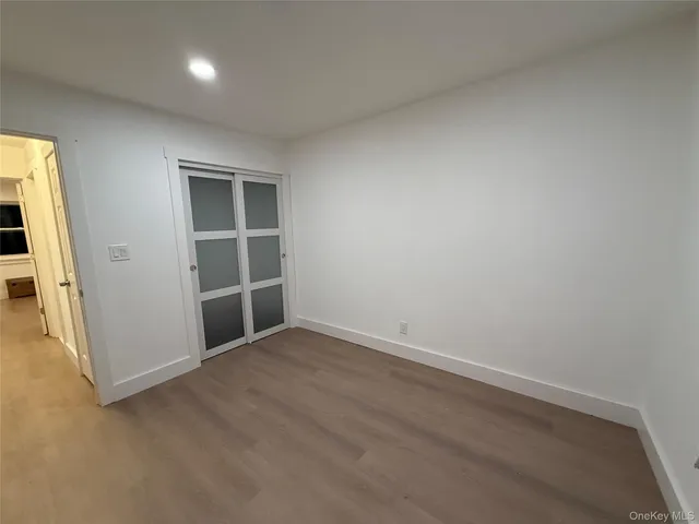 an empty room with wooden floor and window