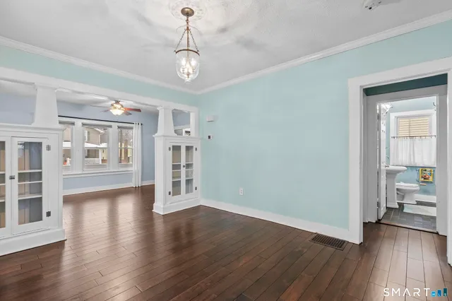 a view of an empty room with window and wooden floor