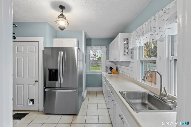 a kitchen with a refrigerator sink and cabinets
