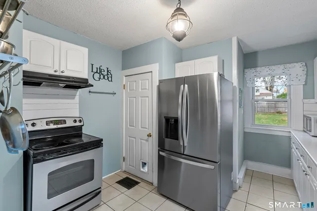 a kitchen with stainless steel appliances granite countertop a refrigerator a stove and a sink