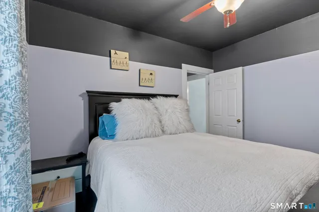 a large bed sitting in a bedroom next to a chandelier