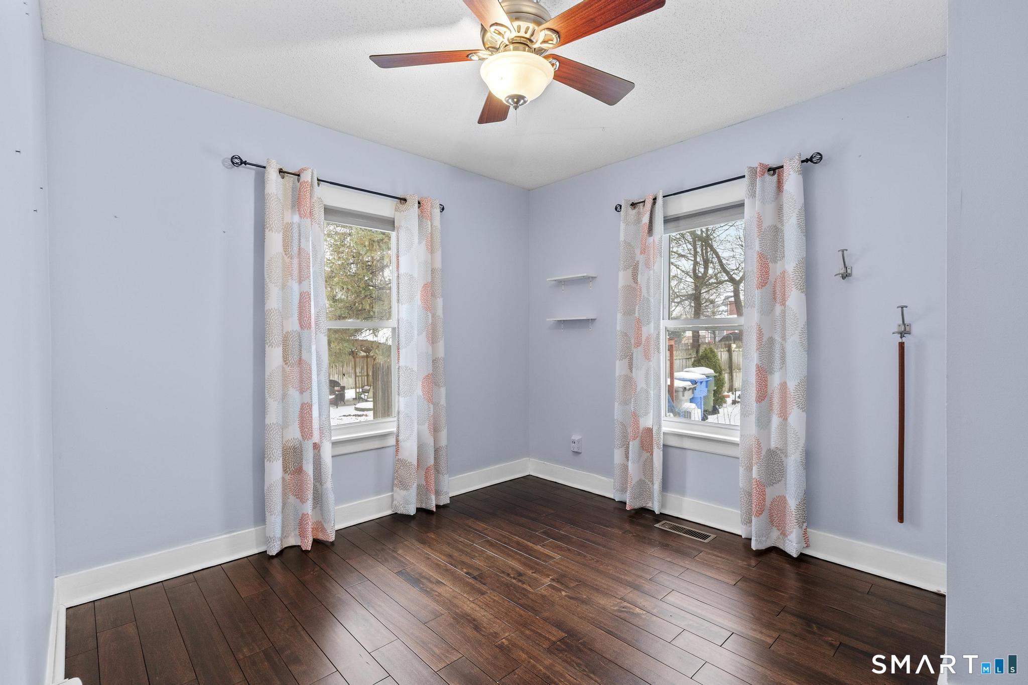 64 Douglas Road Bristol, CT 06010 - Photo 32 of 40 an empty room with wooden floor a ceiling fan and windows