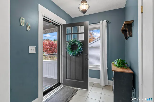 an entryway with a flower pot and a bookshelf