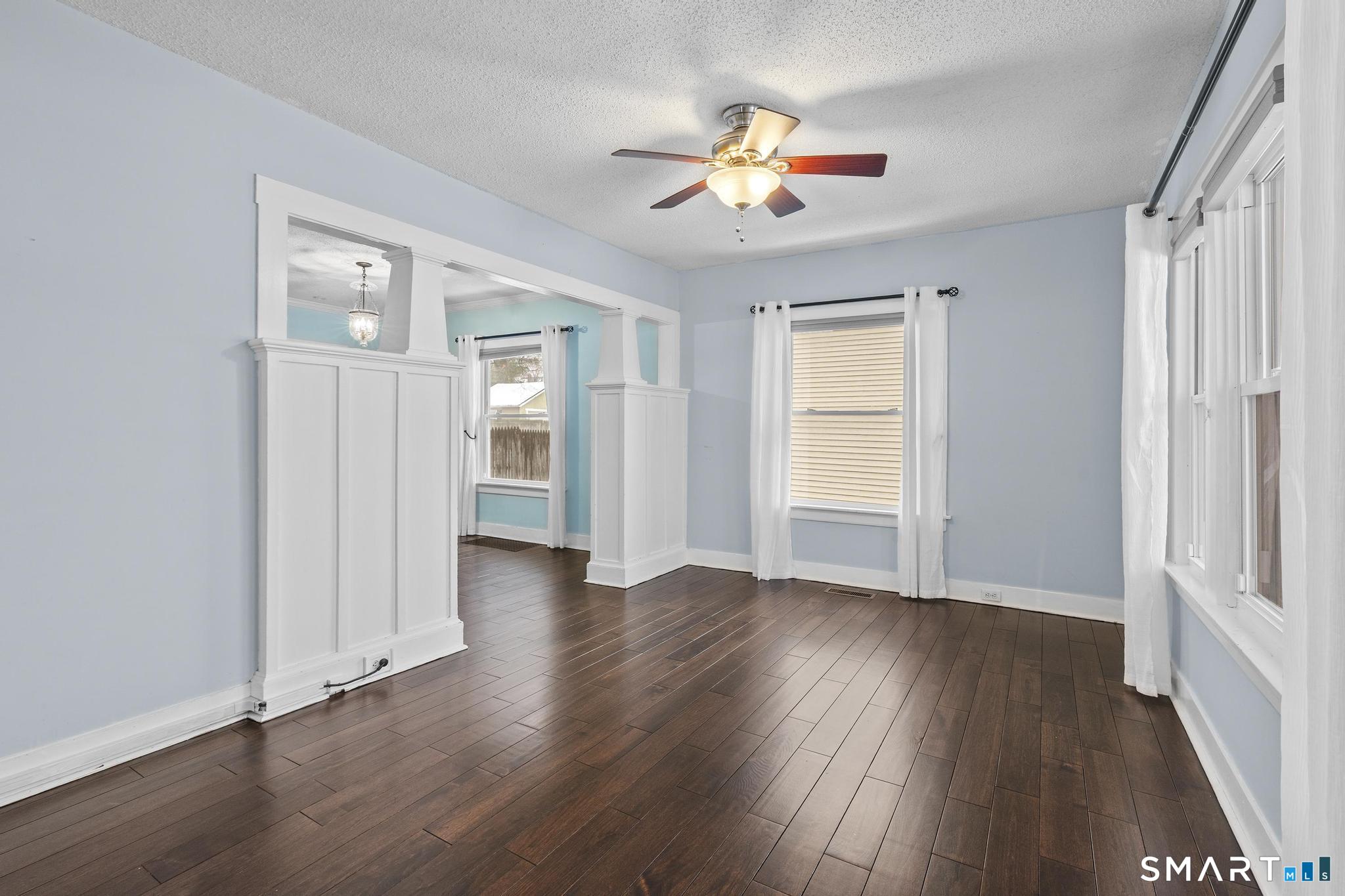 64 Douglas Road Bristol, CT 06010 - Photo 9 of 40 an empty room with wooden floor chandelier and windows
