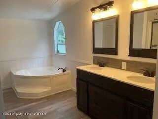 a bathroom with a tub sink and mirror