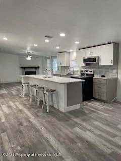 a kitchen with stainless steel appliances granite countertop a stove top oven a sink dishwasher and a refrigerator