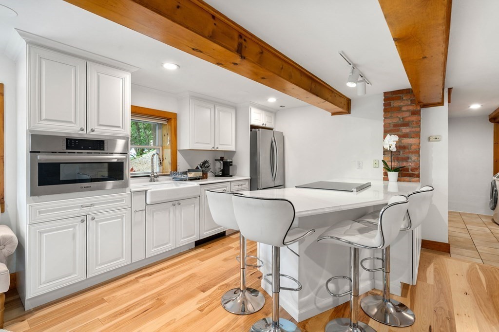 10 Beech Road Wayland, MA 01778 - Photo 5 of 42 a kitchen with stainless steel appliances granite countertop a white cabinets and a stove top oven