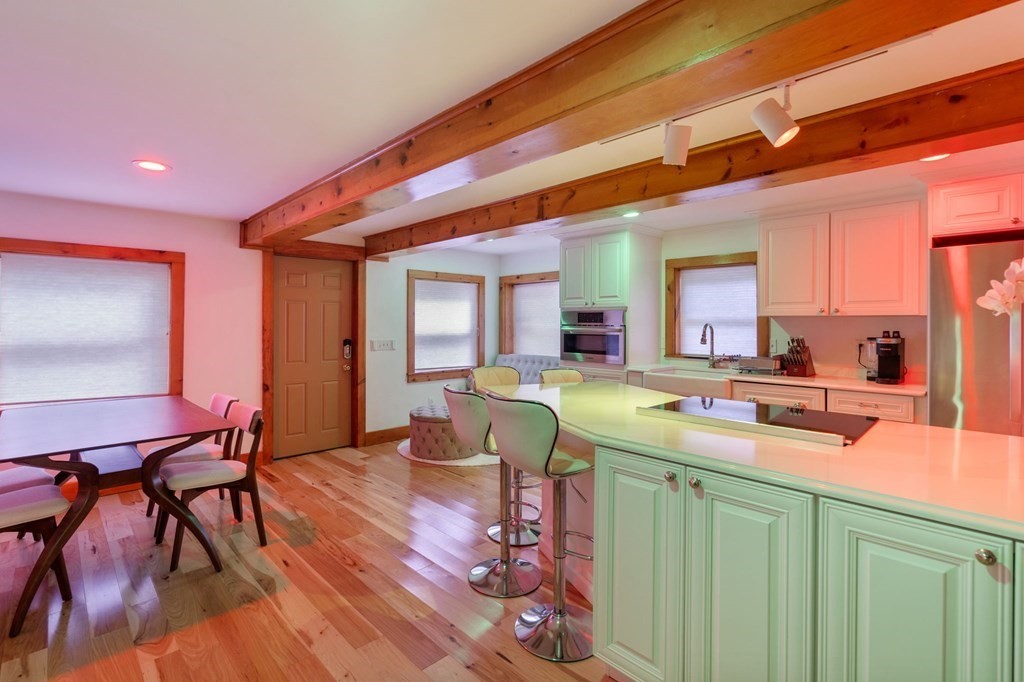 10 Beech Road Wayland, MA 01778 - Photo 8 of 42 a kitchen with a table chairs and a refrigerator