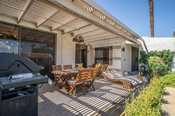 a view of a patio with table and chairs potted plants