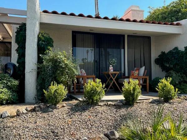 a view of a house with yard and sitting area