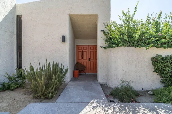 a front view of a house with a tree