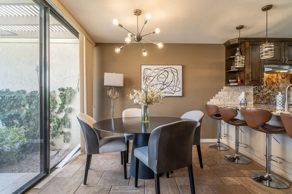 a view of a dining room with furniture a chandelier and wooden floor