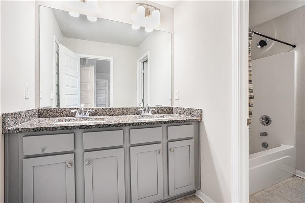 2428 Hanover Woods Road Lithonia, GA 30058 - Photo 12 of 26 a bathroom with a granite countertop sink and a mirror